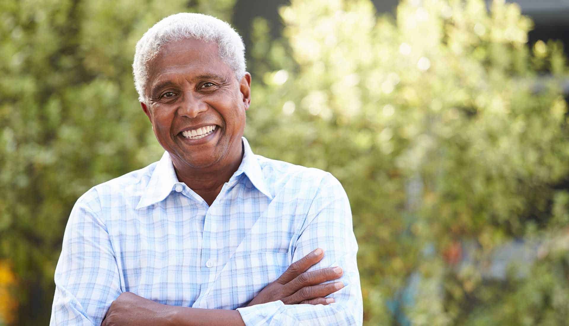 Smiling senior African American man with arms crossed.