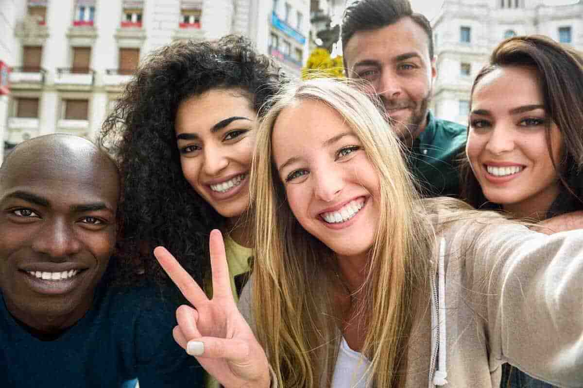 Multiracial group of young people taking selfie.